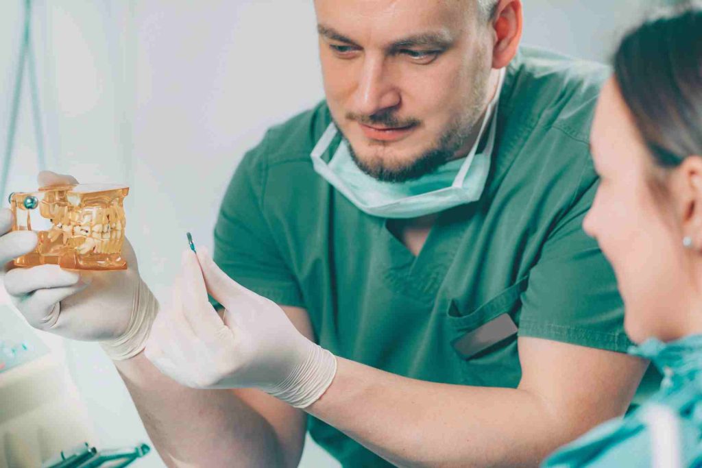 Dentist explaining dental implant procedure to patient.