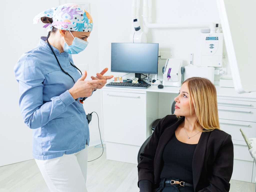 Dentist explaining treatment to patient in modern dental clinic