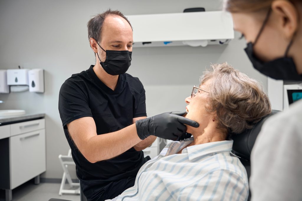 medical professional examining senior woman in clinic