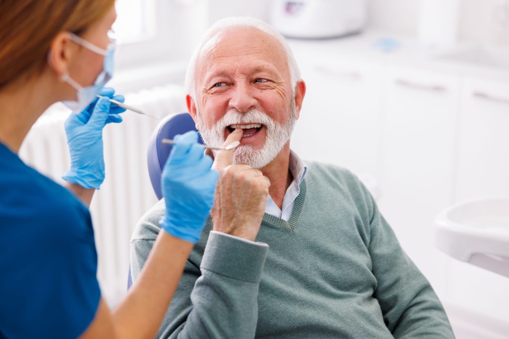 Senior Man Smiling at Dentist Office Checkup